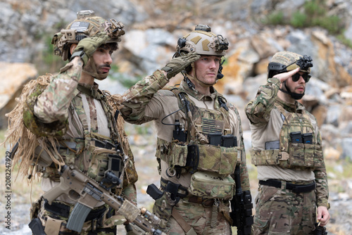 Members of the military unit are lined up in formation with hand saluted