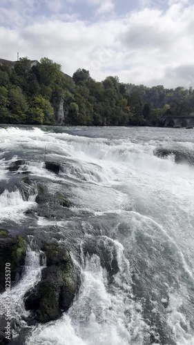 Schaffhausen, Switzerland - October 11, 2025: View of the Rhine Falls, Europe’s largest waterfall, with powerful cascades and the surrounding landscape on an autumn day.