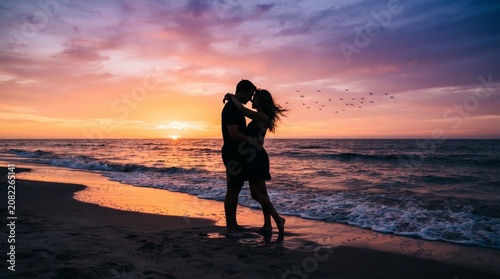 Silhouette Couple Embracing on Beach at Sunset, Ocean Waves and Orange Purple Sky Gradient, Wide Romantic Banner Illustration