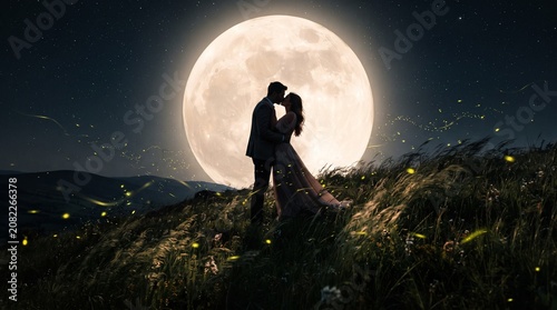 Couple Kissing Silhouette Under Giant Glowing Moon on Hilltop, Fantasy Romantic Illustration with Fireflies and Tall Grass