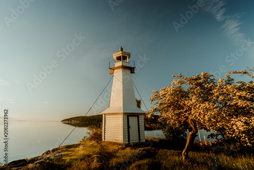 Minimalist Swedish lighthouse against golden hour sky, Lake Vattern, Sweden.