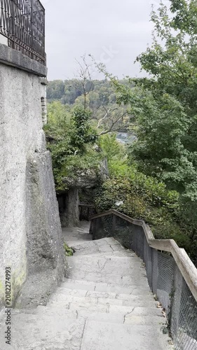 Schaffhausen, Switzerland - October 11, 2025: Historic cobblestone street and old stone walls near the Rhine Falls, leading visitors toward the famous natural attraction.