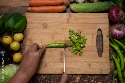 Фотография Slicing Fresh Green Chili on Wooden Cutting Board
