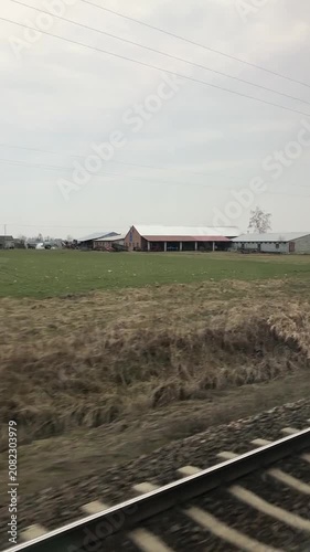 Train Passing Rural Landscape with Overcast Sky