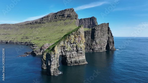 Drone shot of Faroe Island cliffs with Drangarnir Sea Arch and Tindhólmur