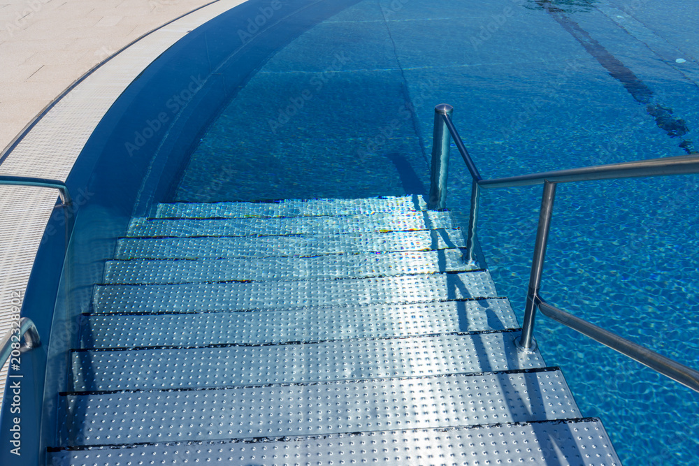 Fototapeta premium Metal steps and handrails in outdoor swimming pool