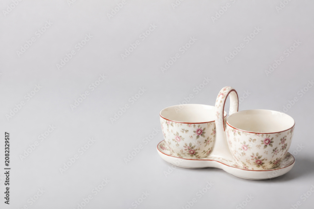 Fototapeta premium Floral tea cups on a connected tray. Space for text.