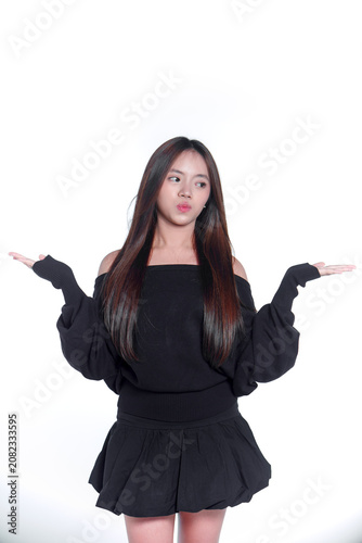 Portrait of a playful young Asian woman shrugging with her hands out