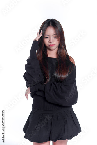 Portrait of a worried young Asian woman touching her head and looking down