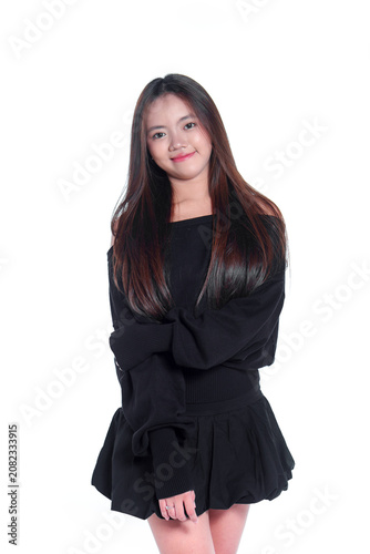 Portrait of a confident young Asian woman in casual black clothing standing and smiling