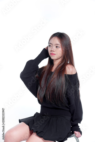 Portrait of a young Asian woman in black casual clothing looking away thoughtfully