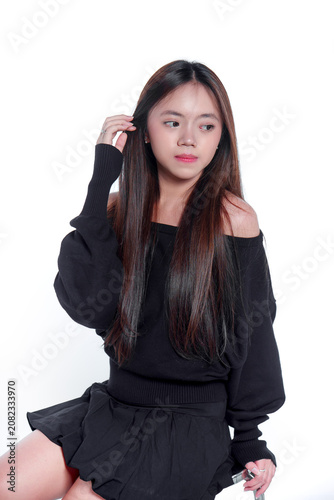 Portrait of a young Asian woman in black casual clothing looking away thoughtfully