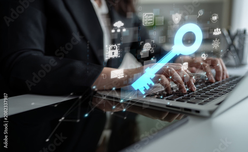 Obraz na plátne Business executive using laptop with digital key overlay and technology icons re
