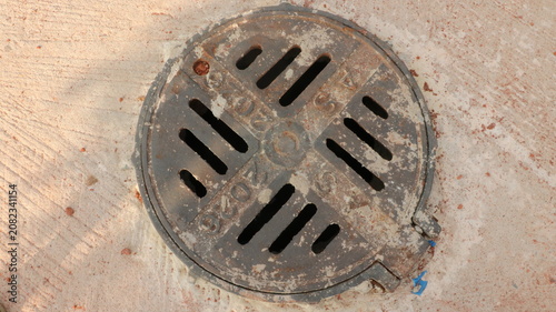 фотографія Old rusty metal drain cover on concrete floor with concrete infrastructure circu
