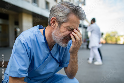 Stressed male nurse outside hospital building