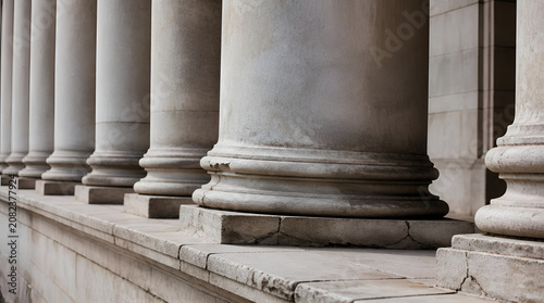 Elegant Row of Ancient Stone Pillars with Detailed Bases in Classical Architecture