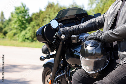 Obraz na płótnie Man with helmet on modern motorcycle outdoors, closeup