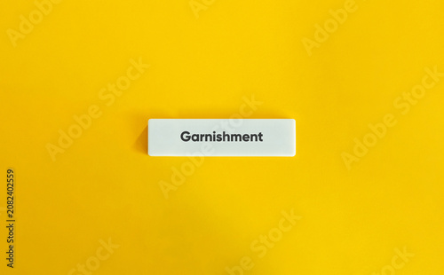 Fotografie Garnishment word on white bar over yellow background