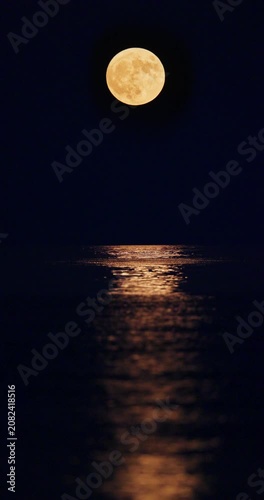 Full strawberry moon with bright moonpath reflection on sea water at night beautiful landscape