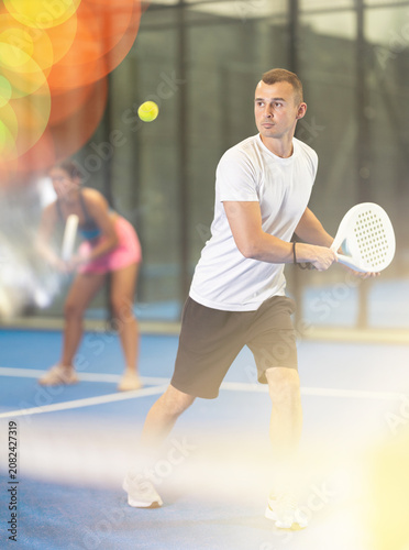 Padel game - girl with partners plays on the tennis court