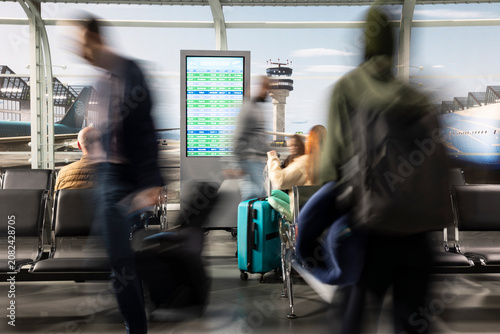 Quadro su tela Rushing, trolleys and diverse passengers in airport terminal, fast movement concept, carrying luggage, international transit and travelers in busy transportation hub departure area