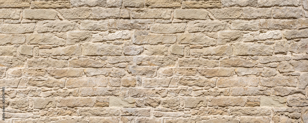 Fototapeta premium Old limestone rock wall presenting rough texture surface