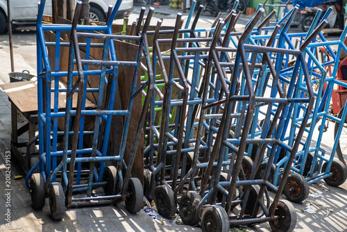 Quadro su tela A row of blue and black heavy-duty hand trucks lined up along a paved roadside near a traditional market in Central Java, Indonesia