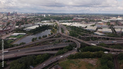Smooth sideways drone flight across the famous Spaghetti Junction motorway interchange in Birmingham, England. The aerial footage captures the complex network of elevated M6 highways, curved flyovers,