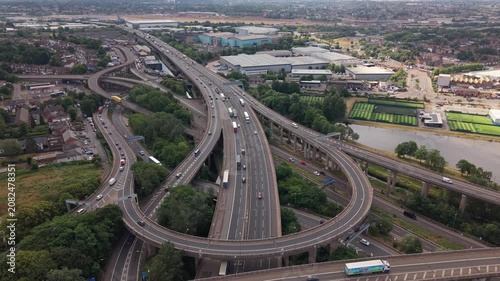 Smooth backward drone flight over the iconic Spaghetti Junction motorway interchange in Birmingham, England. The aerial footage reveals the intricate network of elevated M6 highways, curved flyovers, 