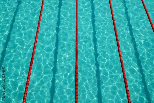 Overhead view of swimming pool lanes with turquoise water and red ropes
