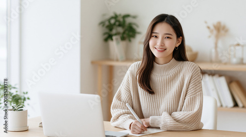 A person sits relaxed at a desk with natural lighting and plants nearby