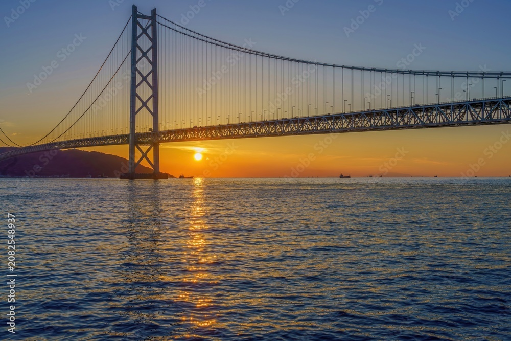 Obraz premium 夕日に映える明石海峡大橋と瀬戸内海の美しい夕暮れ風景