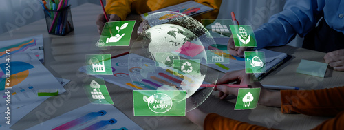 Tableau sur toile A vibrant workspace showing hands collaborating on eco-friendly initiatives, featuring earth representation and symbols for sustainability and climate action strategies