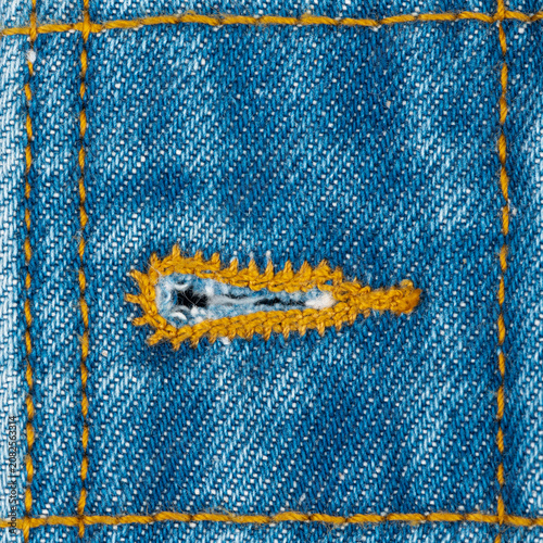 Fotografie Close up of denim fabric buttonhole with yellow stitching