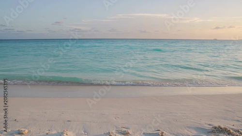 Gentle waves wash onto soft sand at dusk