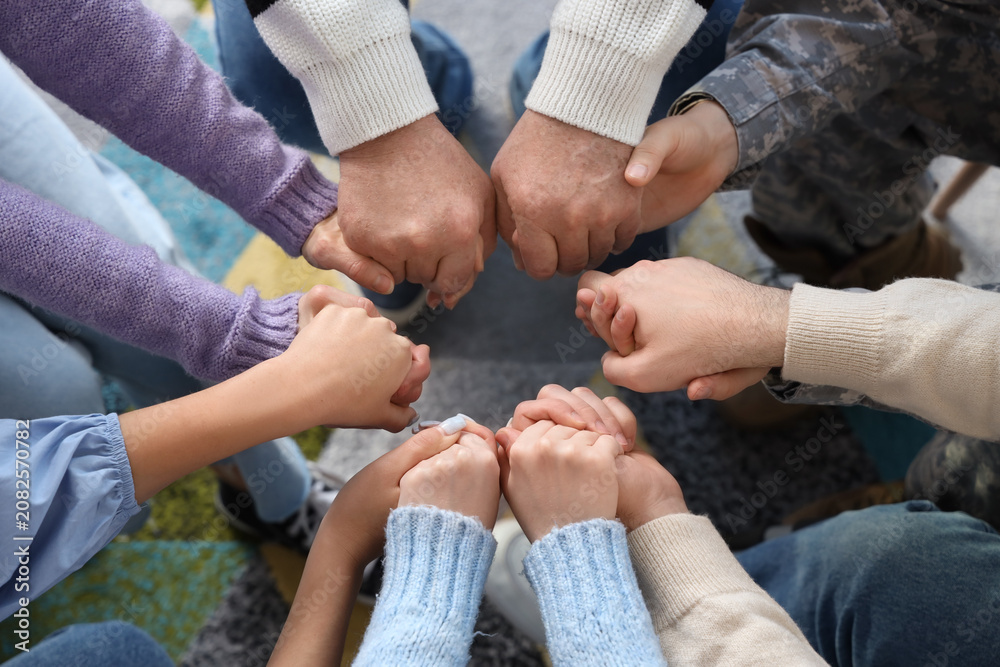 Obraz premium People holding hands at group therapy session, closeup