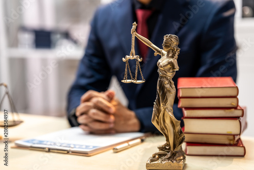 Bild auf Leinwand Lawyer office desk with justice statue, scales, legal books and laptop, showing professional legal advice, court concept and balanced decision making