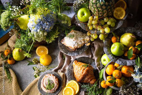Elegant gourmet breakfast still life featuring fresh fruits, pastries, and rustic tableware arranged in a luxurious artistic composition