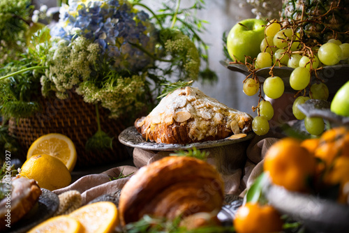 Elegant gourmet breakfast still life featuring fresh fruits, pastries, and rustic tableware arranged in a luxurious artistic composition