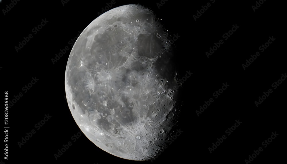 Fototapeta premium Waning moon phase detail against deep black sky