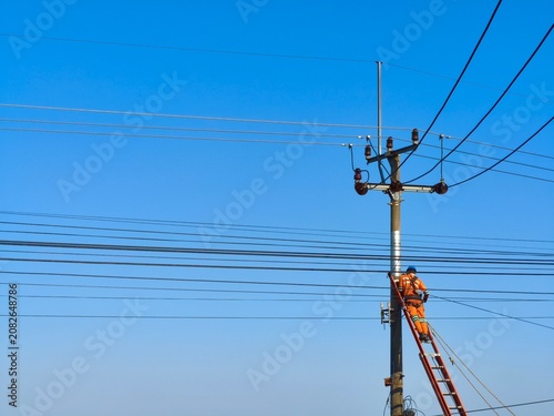 Bild auf Leinwand a worker repairing power lines on a utility pole