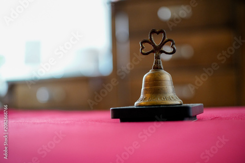 Small Vintage Brass Bell on a Red Surface