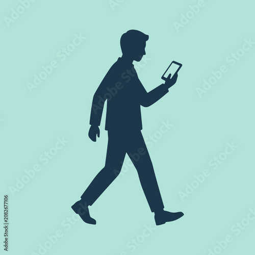 A dark silhouette of a man walking while using a smartphone