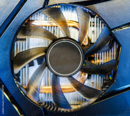 Closeup of Cooling Fan and Heatsink. A computer or graphics card cooling system featuring dark fan blades and metallic copper heat pipes on heatsink, highlighting advanced thermal management hardware.