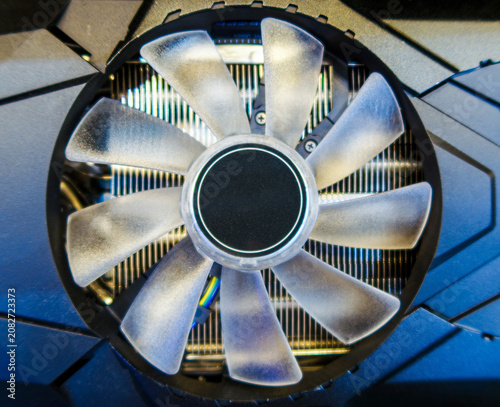 Closeup Modern Hardware of Cooling Fan and Heatsink System. Detail of a computer or graphics card cooling fan with translucent blades and aluminum heatsink, representing thermal management technology.
