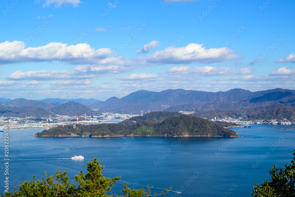 Obraz premium Elevated view of the Seto Inland Sea with a passing ferry and coastal mountains