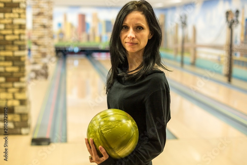 Fotografie Confident Woman Holding a Green Bowling Ball at an Alley