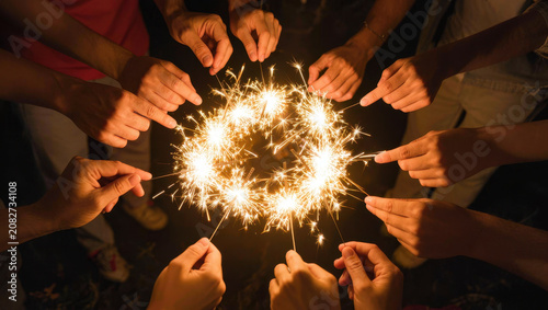 Sparks circle with hands around festive glow in dark celebration