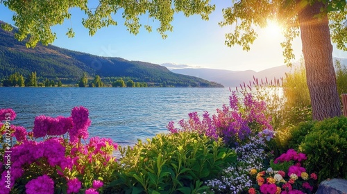 Serene lakeside landscape framed by vibrant flowering plants and distant mountains under bright sunlight