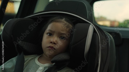 preschool child girl sitting in car seat with sunlight, safety baby chair travelling